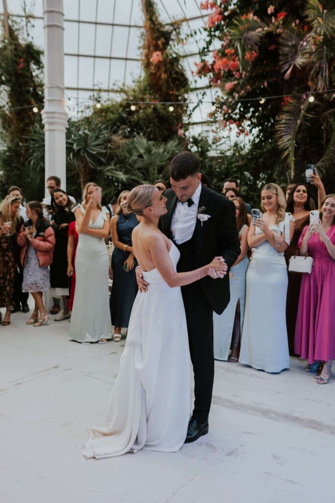 Newlyweds during their first dance surrounded by botanicals in the Palm House at Sefton Park